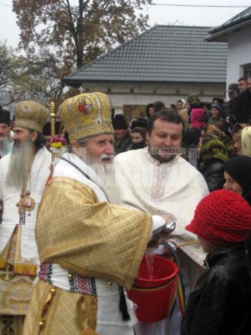 Pimen, stropind cu aghiazma mulțimea adunată la sfințirea bisericii