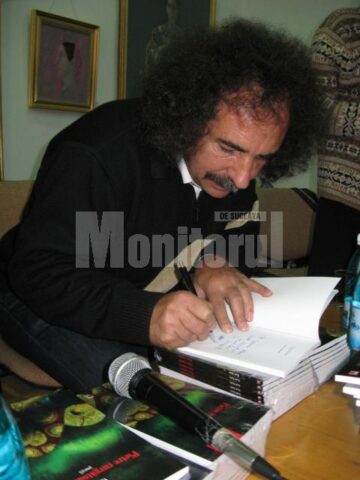 Vasile Tudor oferind autografe pe volumul său de debut