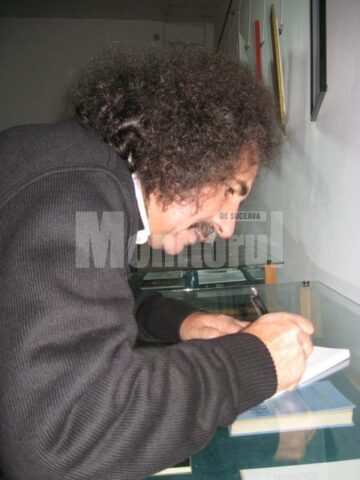 Vasile Tudor oferind autografe pe volumul său de debut