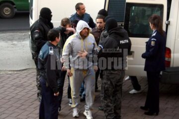 Alexie Pitișciuc, zis Vâju (cu gluga pe cap), alături de câțiva dintre „tovarășii” săi, în fața Palatului de Justiție