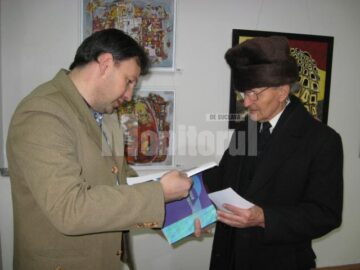 Artiștii plastici Iulian Asimionesei și Mihai Ferbei cu catalogul salonului