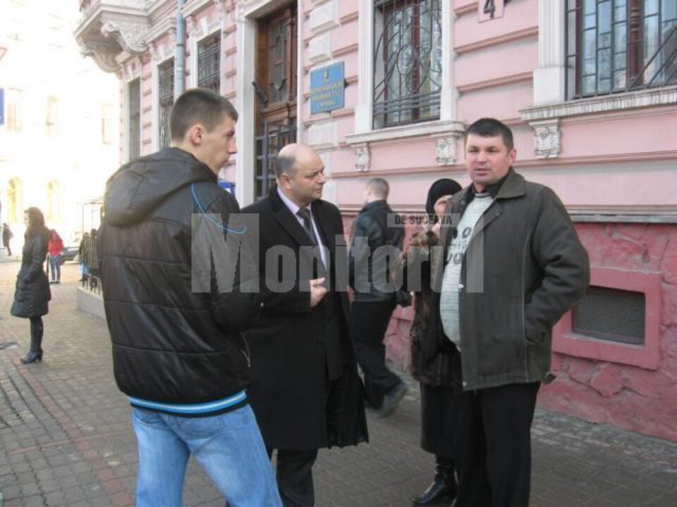 Vasile Hrițcu, însoțit de fiul său și soacra sa, alături de avocatul care îi reprezintă, în fața Judecătoriei Raionului Șevcenco Cernăuți Vasile Hrițcu, însoțit de fiul său și soacra sa, alături de avocatul care îi reprezintă, în fața Judecătoriei Raionului Șevcenco Cernăuți