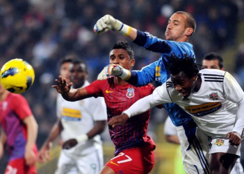 Milan Borjan (dreapta), portarul echipei FC Vaslui, respinge un balon de lângă Leandro Tatu (stânga), de la Steaua București