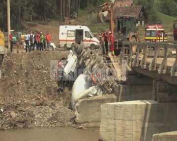 Șoferul a pătruns cu vehiculul greu, încărcat, pe un pod din lemn care a cedat, răsturnându-se în albie