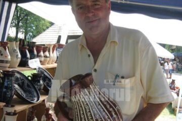 Meșterul popular băimărean Cornel Sitar ținând în mâini un ulcior numit cana mester