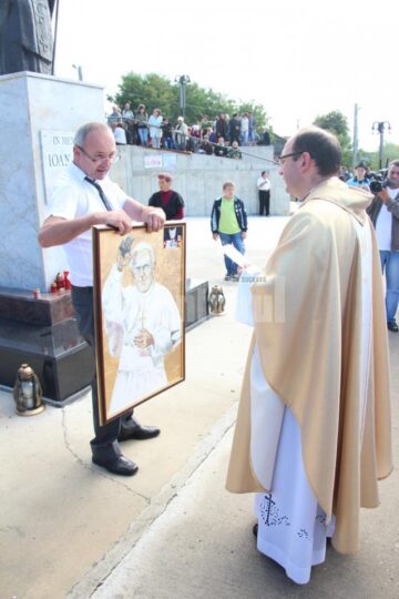 Dan Răican, donând Bisericii din Cacica un tablou pictat de o tânără fără mâini