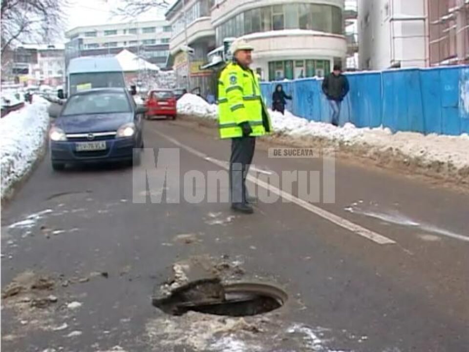 Polițiștii, chemați să dirijeze traficul pentru a evita ca și alte mașini să cadă în gura de canal