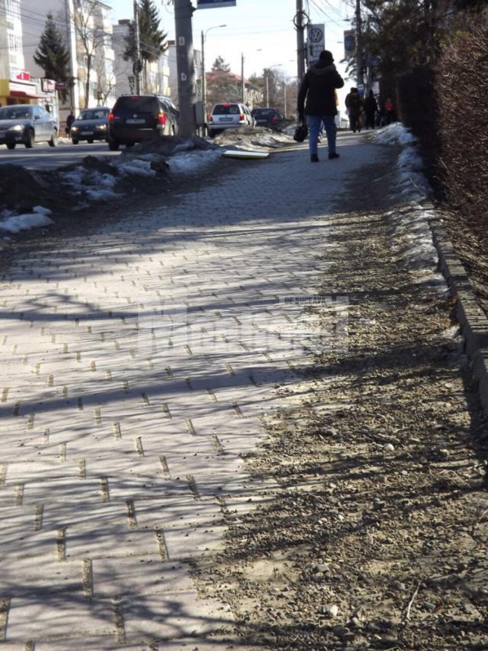 Nisipul și pietrișul date ca antiderapant pe trotuarul din fata Primăriei Suceava