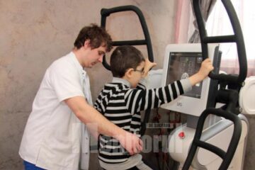 Denis în timpul unei ședințe pe Huber Motion Lab, ajutat de kinoterapeutul George Morari