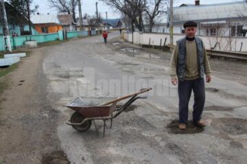 Sătenii s-au transformat în drumari și acoperă gropile cu pământ
