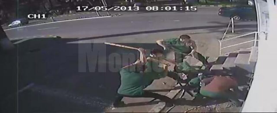 Bărbatul este trântit la pământ, iar agresorii îl lovesc peste corp cu bâtele
