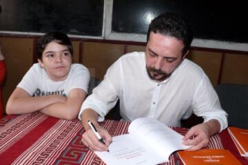 Daniel Șandru dă autografe la lansarea de la Rădășeni
