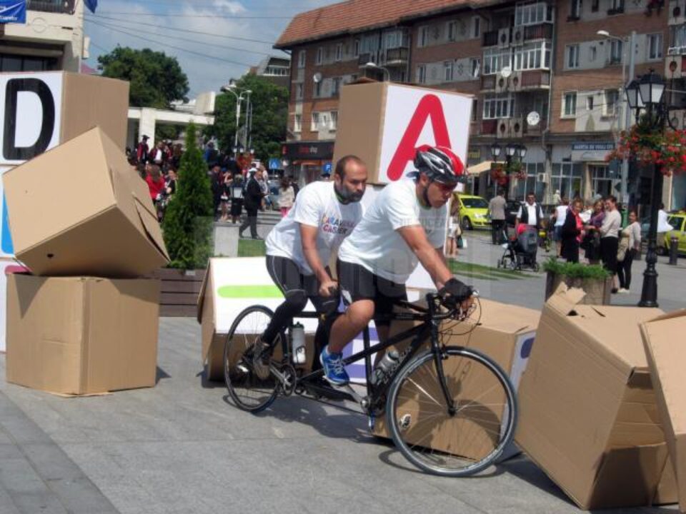 Zidul simbolic din cuburi de carton pe care scria „Dizabilitate” a fost dărâmat de cei doi bicicliști Zidul simbolic din cuburi de carton pe care scria „Dizabilitate” a fost dărâmat de cei doi bicicliști