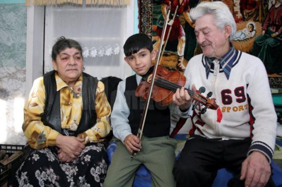 Străbunicii Tereza si Mihai, alături de Loris, acum 6 ani, când a primit în dar o vioară