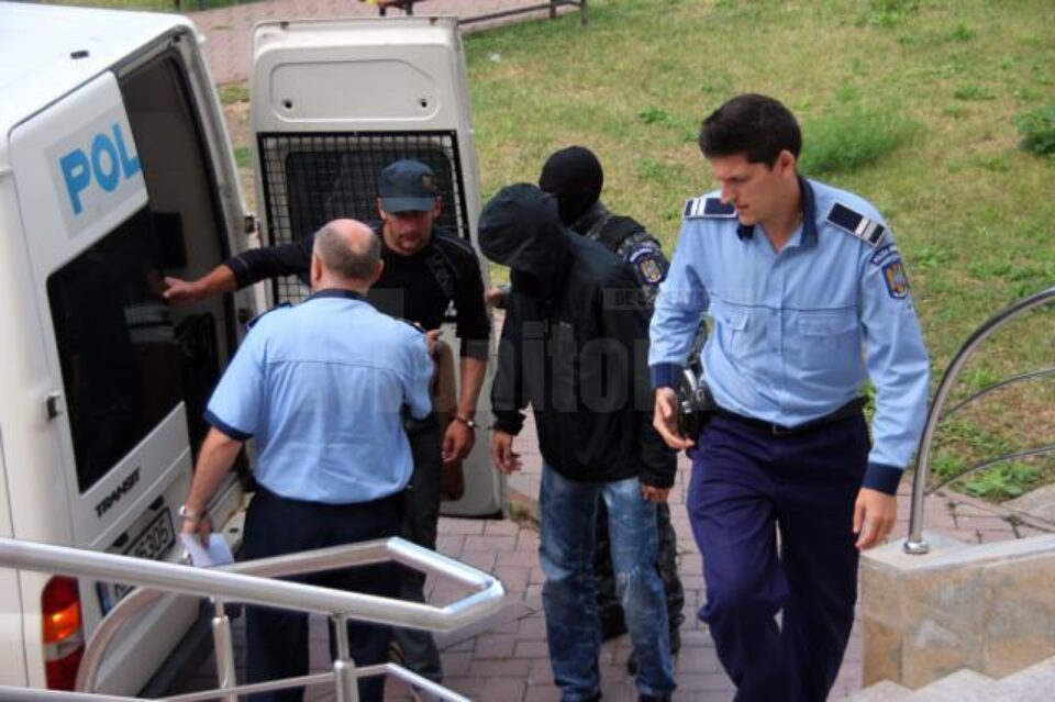 Fostul polițist Olinici (cu gluga pe cap) și Mihai Halip împart aceeași pereche de cătușe Fostul polițist Olinici (cu gluga pe cap) și Mihai Halip împart aceeași pereche de cătușe