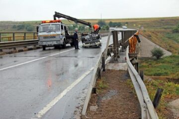 Șoferul a derapat pe carosabilul umed, a încălecat bara de protecție și s-a răsturnat