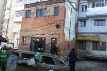 Bucăți din tencuiala fațadeii blocului s-au desprins peste copertina care s-a prăbușit chiar la intrarea în bloc