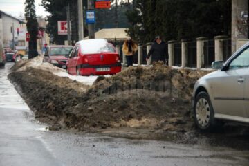 Zăpada amestecată cu nisip și sare străjuiește lateralele străzilor, ca o barieră de mizerie