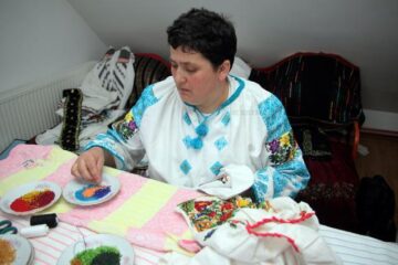 Elena Iurciuc, din Șerbăuți, împodobește cămășile tradiționale cu mii de mărgele colorate