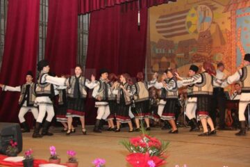 Interpreți de muzică populară, instrumentiști, dansatori, pe aceeași scenă, într-un spectacol dedicat mamei