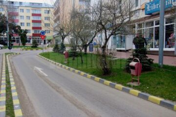 Coșuri de gunoi montate cu fața spre stradă, pe unde trec doar mașinile