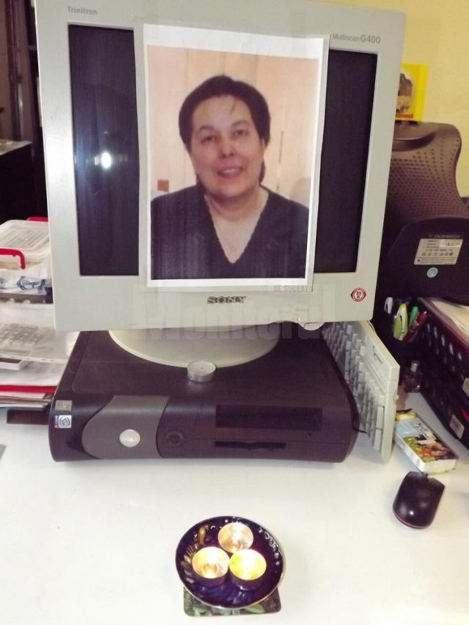Fotografia Magdei Ghiață, lipită de colegi pe monitorul computerului pe care lucra, în fața căruia au aprins câteva lumânări Fotografia Magdei Ghiață, lipită de colegi pe monitorul computerului pe care lucra, în fața căruia au aprins câteva lumânări