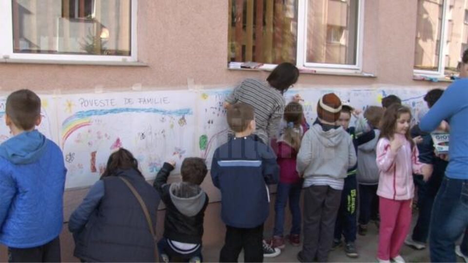 Pe coli de dimensiuni mari, expuse pe pereții din exteriorul grădiniței, la înălțimea copiilor, micuții au ilustrat „povești de familie”