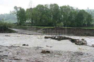 Podețul din tuburi de beton a fost măturat de apele învolburate încărcate de gunoaie
