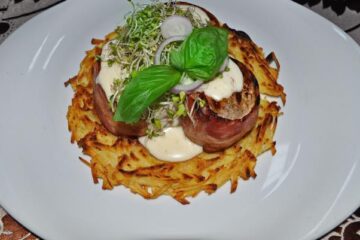 Mușchiuleț de porc cu sos de brânzeturi pe un pat de cartofi Rosty