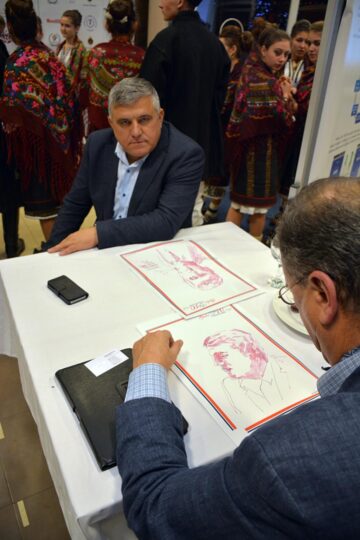 Maestrul Mihai Pânzaru-Pim a dăruit și el câte un portret câștigătorilor licitațiilor. Foto: ArTiStul