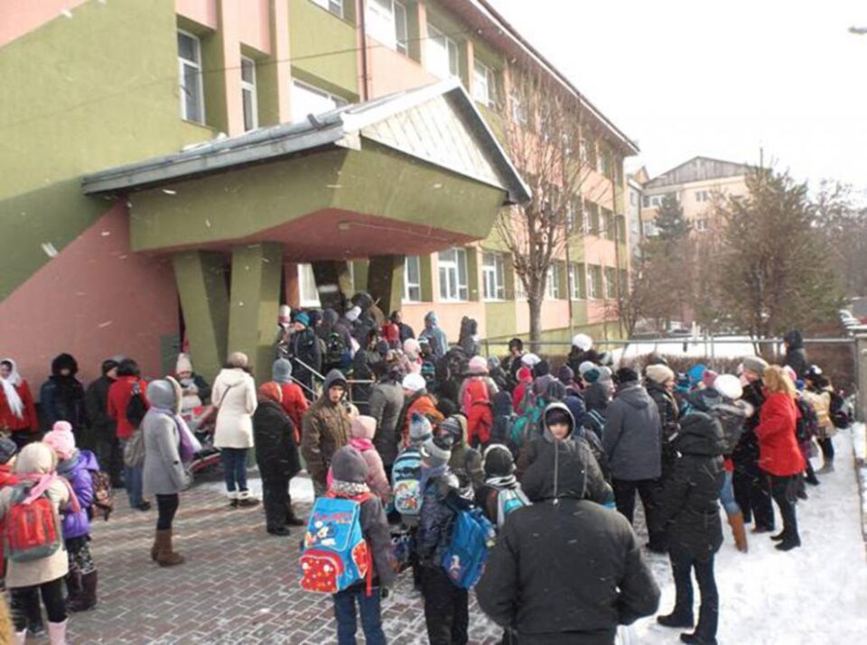 Copiii așteaptă permisiunea de a intra în școală
