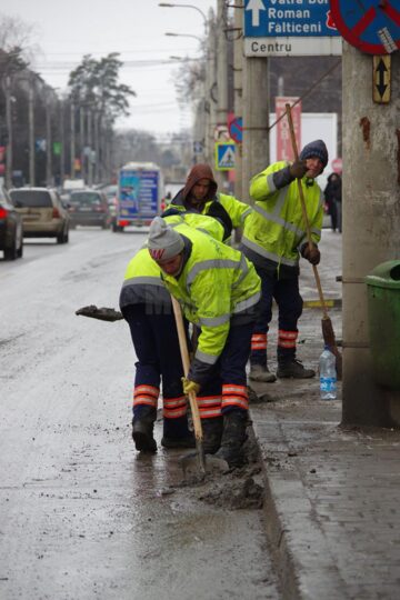 Trei echipe ale Diasil adună mormane de pietriș, nisip și pământ din rigolele stradale