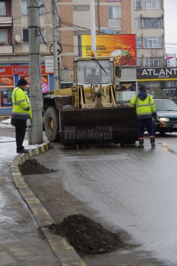 Trei echipe ale Diasil adună mormane de pietriș, nisip și pământ din rigolele stradale