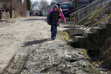 Copiii de pe această stradă merg zilnic la școală prin nămol până la glezne