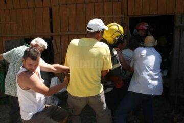 Săteni și pompieri încercând să scoată tăurașul din beci