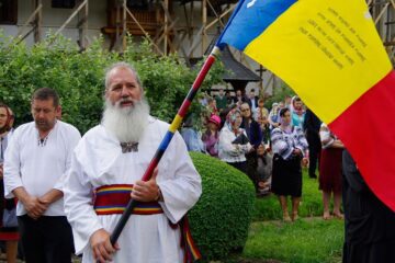 Oameni de toate vârstele, mulți dintre ei îmbrăcați în costume populare, purtând în mâini steaguri tricolore