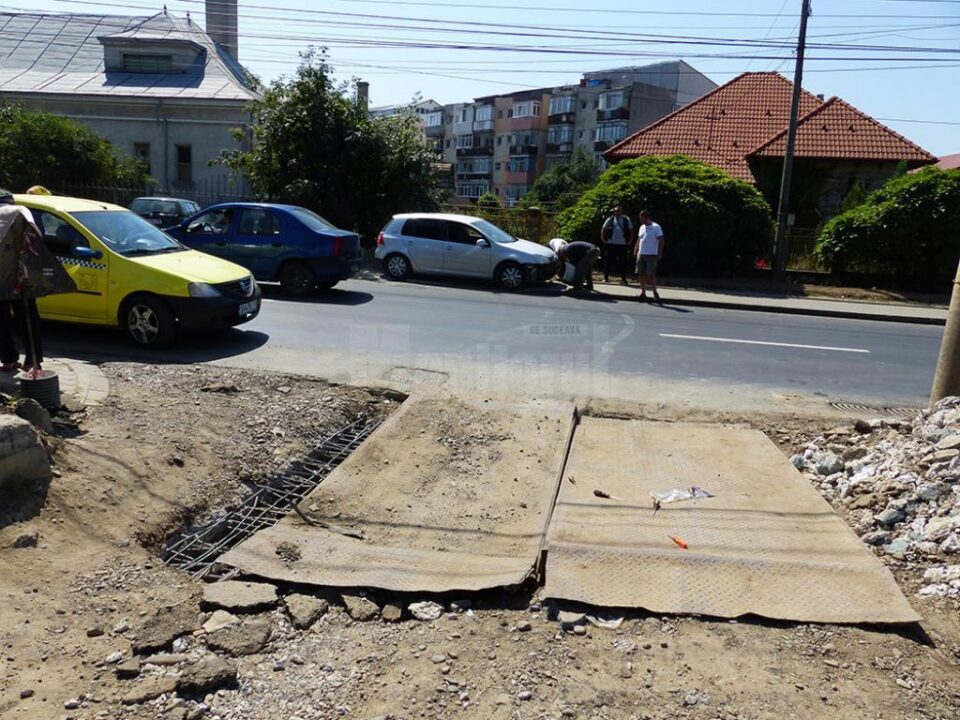 Stradă din Suceava, în șantier, capcană pentru mașini și locul în care muncitorii lucrează sub protecția unui agent de pază