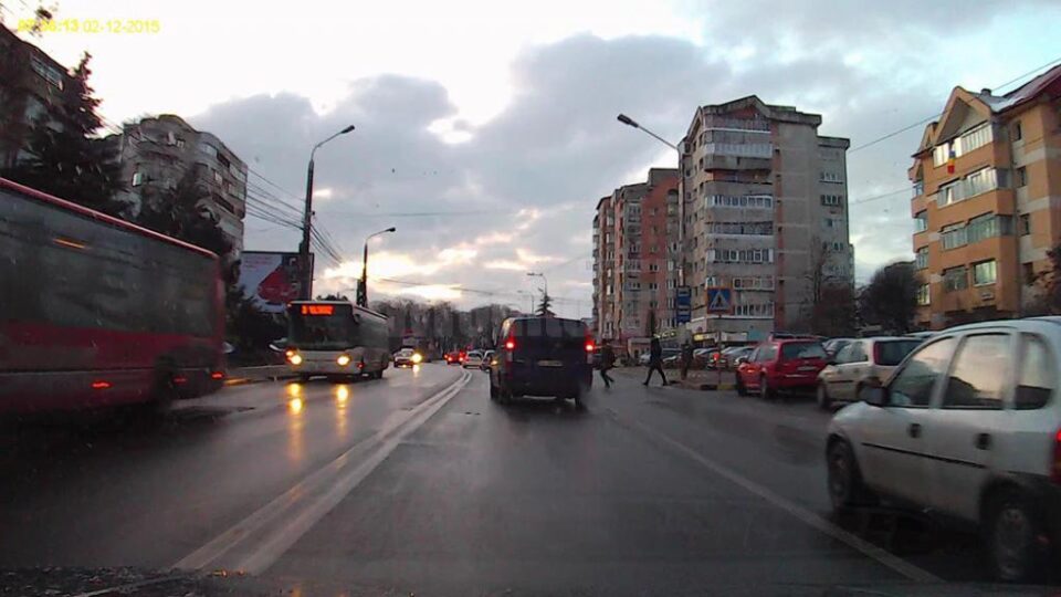 Fata traversa strada pe trecerea de pietoni