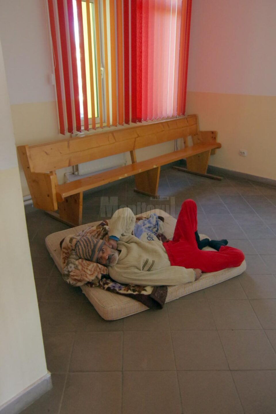 Bătrânul, lăsat pe o saltea în fața biroului de asistență socială