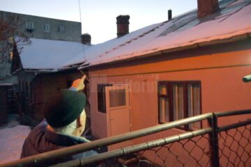 Bătrânul arătând spre coșul de fum care, cel mai probabil, e înfundat