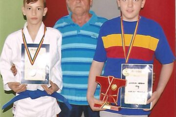 Antrenorul Mihai Pascal alături de doi dintre sportivii săi