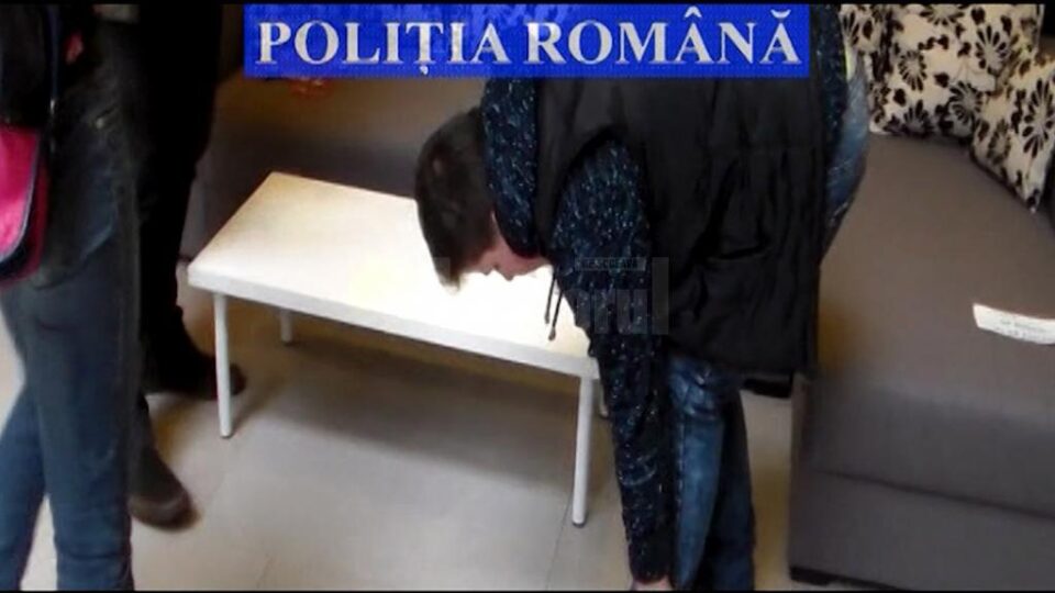 Tânăra de 19 ani, dreapta, percheziționată de o polițistă imediat după ce a încasat o ultimă tranșă de bani de la o victimă