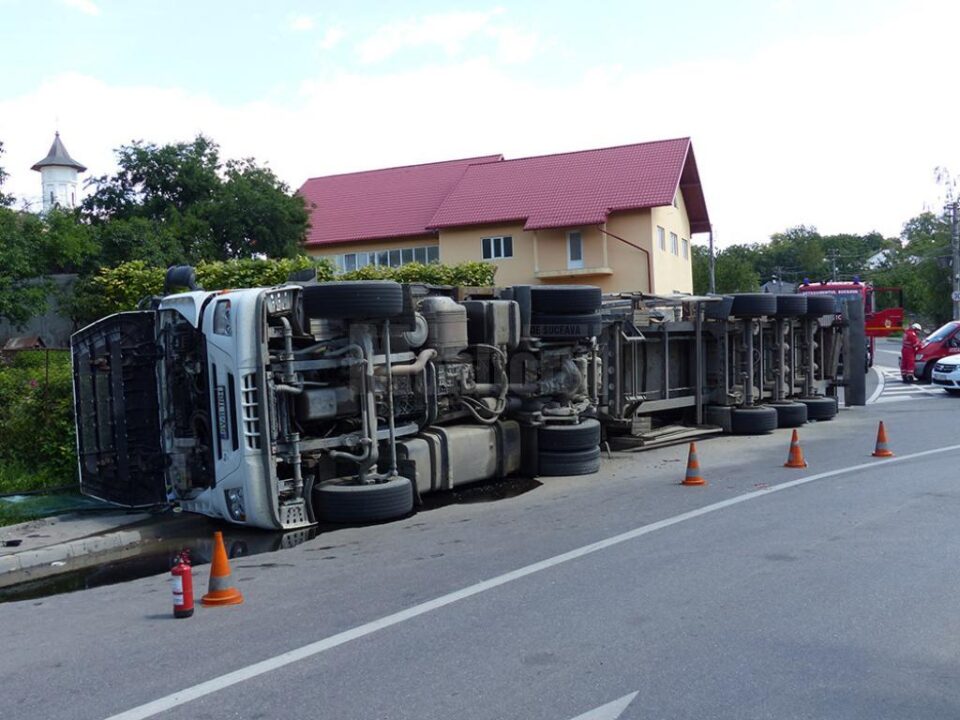 Autocamionul care transporta lemn a fost scăpat de sub control într-o curbă și s-a răsturnat