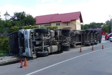 Autocamionul care transporta lemn a fost scăpat de sub control într-o curbă și s-a răsturnat
