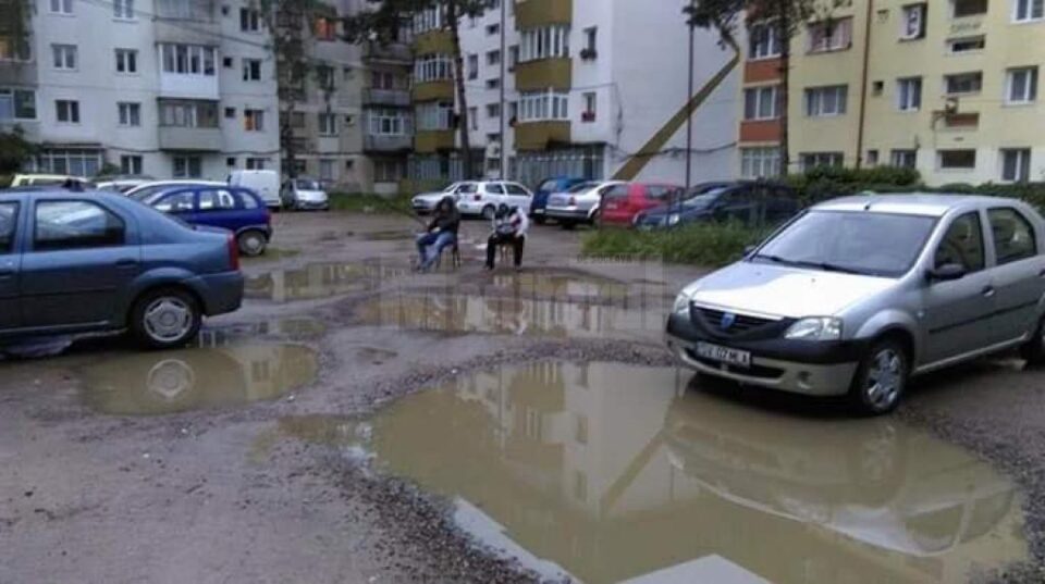 Parcarea dintre blocurile de pe str. Zorilor, unde doi tineri pescuiau în bălțile apărute după o ploaie torențială