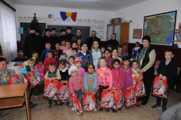 Preoții și reprezentanții Ocolului Solvic Bisericesc, în mijlocul copiilor fericiți, după ce au primit cadouri de Crăciun