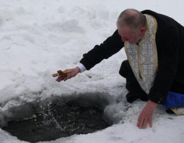 Preotul Domițian Tătaru sfințind apa râului Dorna