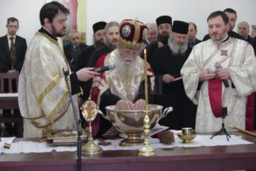 Sfințirea apei în timpul slujbei de către ÎPS Pimen