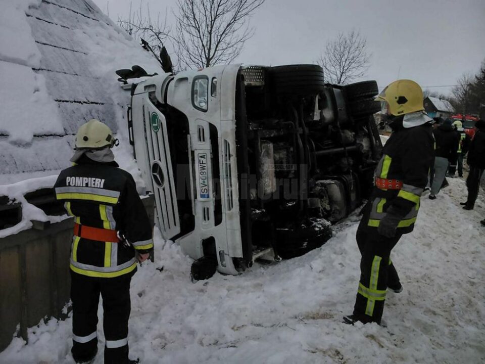 Un tir cu cherestea, plecat în cursă spre Constanța, s-a răsturnat peste o casă, la Milișăuți