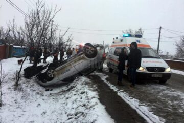 În urma impactului, autoturismul Skoda a lovit un cap de pod și s-a răsturnat la marginea drumului